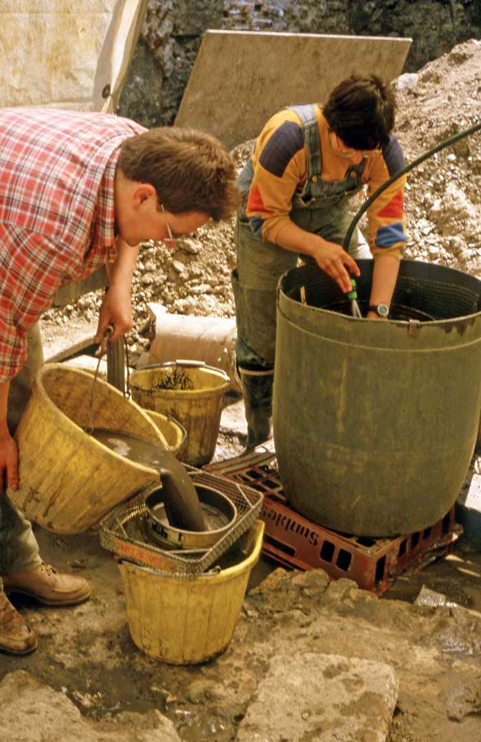 Ken Whitaker undertaking bucket flotation to recover carbonised material and Caroline Pathy-Barker wet-sieving